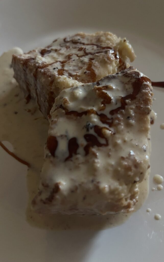 Porción individual de las torrijas de marisa con crema inglesa y al pedro ximenez